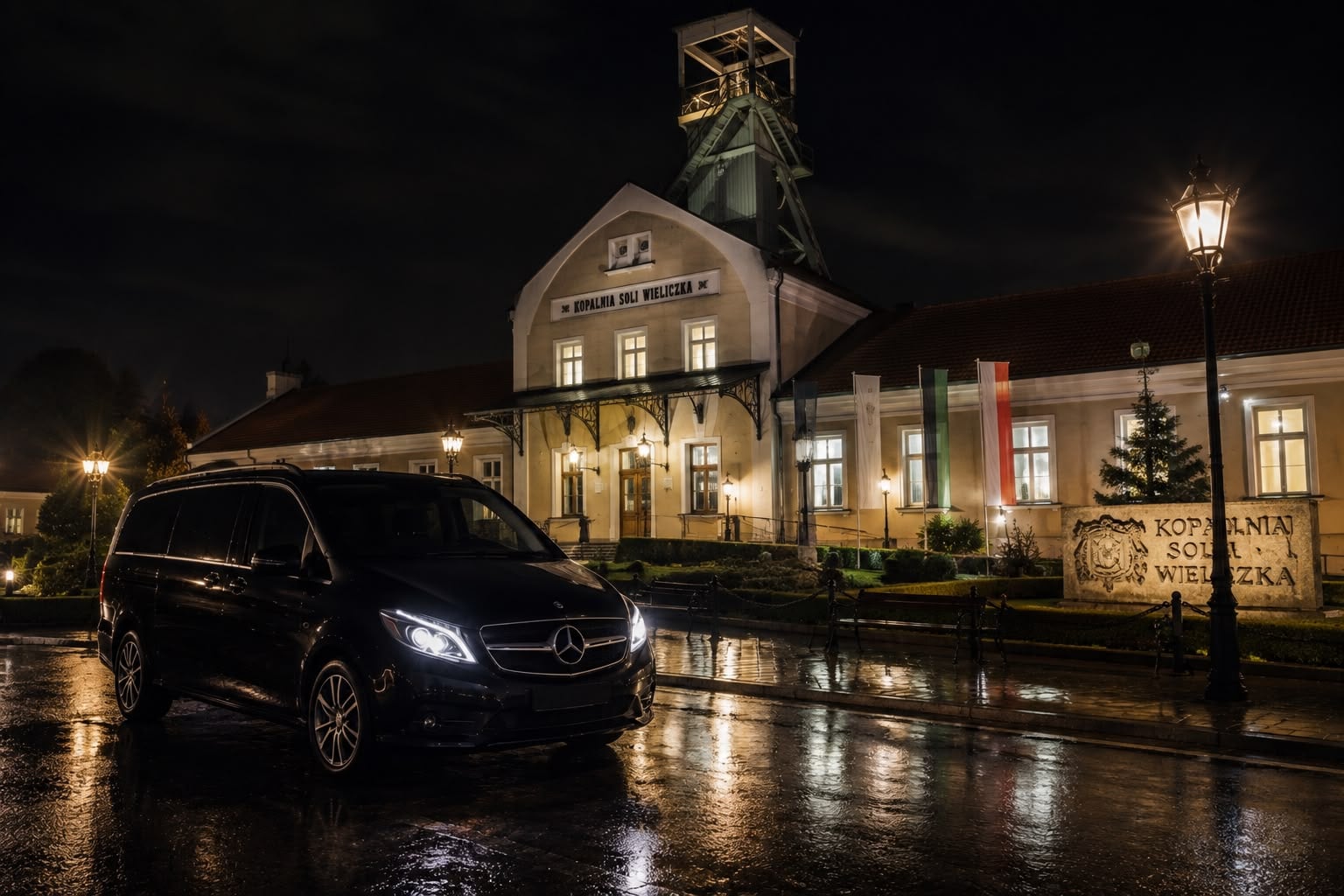 Private Mercedes V-Class transfer vehicle parked outside Wieliczka Salt Mine building at night