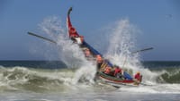 Barco pesquero tradicional cruza olas atlánticas cerca de Aveiro con tripulación