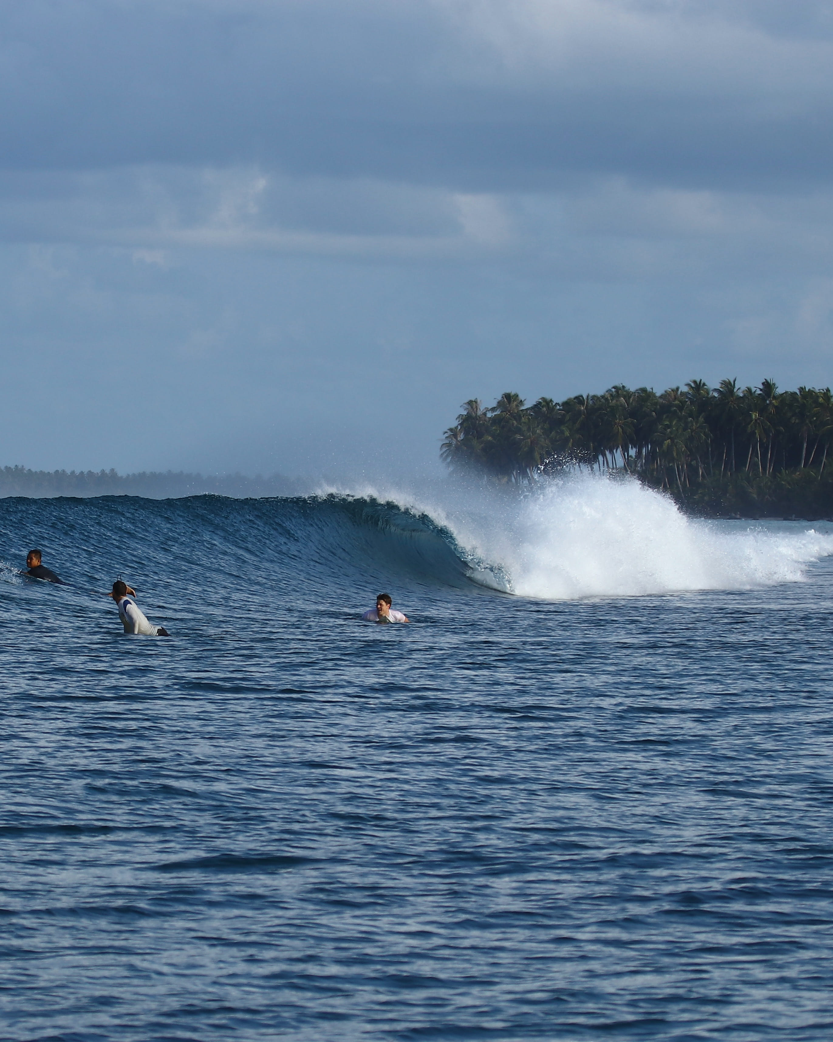 Los surfistas esperan la ola perfecta en la isla Himmafushi, capturados durante un viaje de ForBeyond Travel