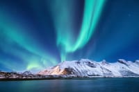 Northern Lights over a snow-covered mountain in Iceland