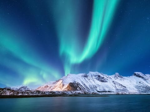 Northern Lights over a snow-covered mountain in Iceland