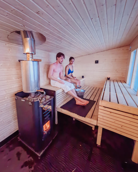 Guests relaxing in a traditional Finnish sauna at StayLapland in Rovaniemi, experiencing the ultimate Finnish wellness tradition.