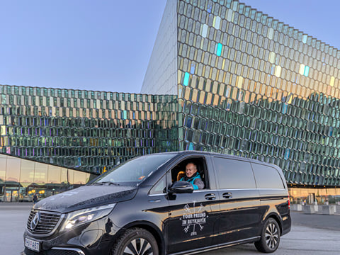 A tour vehicle being driven by a Guide from Your Friend in Reykjavik in front of the Harpa Concert Hall in Reykjavik