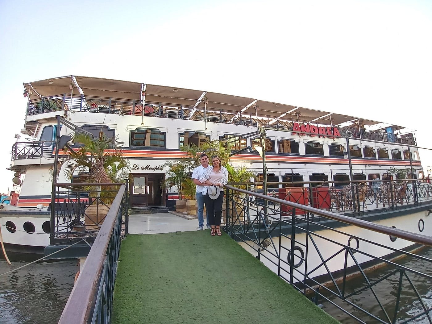 The Andrea Memphis dinner cruise ship lit up with bright white lights at night on the Nile River in Maadi, Cairo