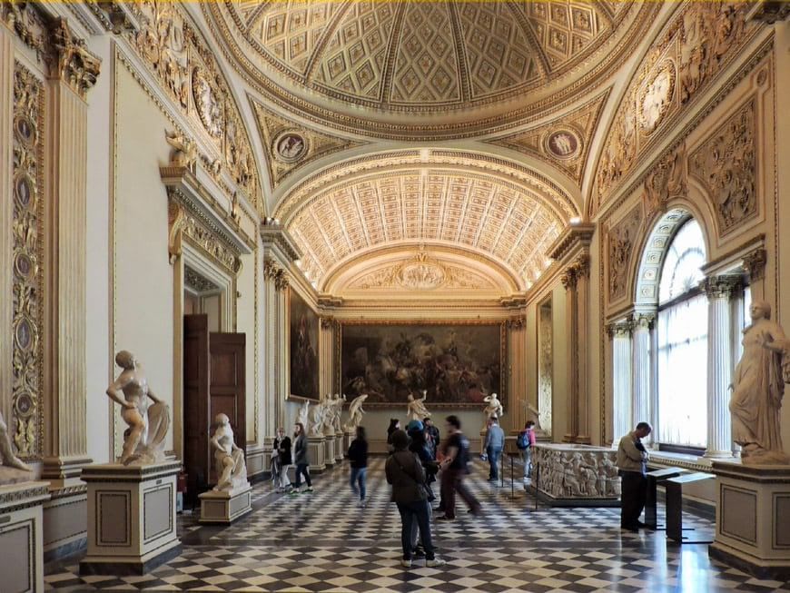 Corridor in the Uffizi Gallery with sculptures and paintings on display 