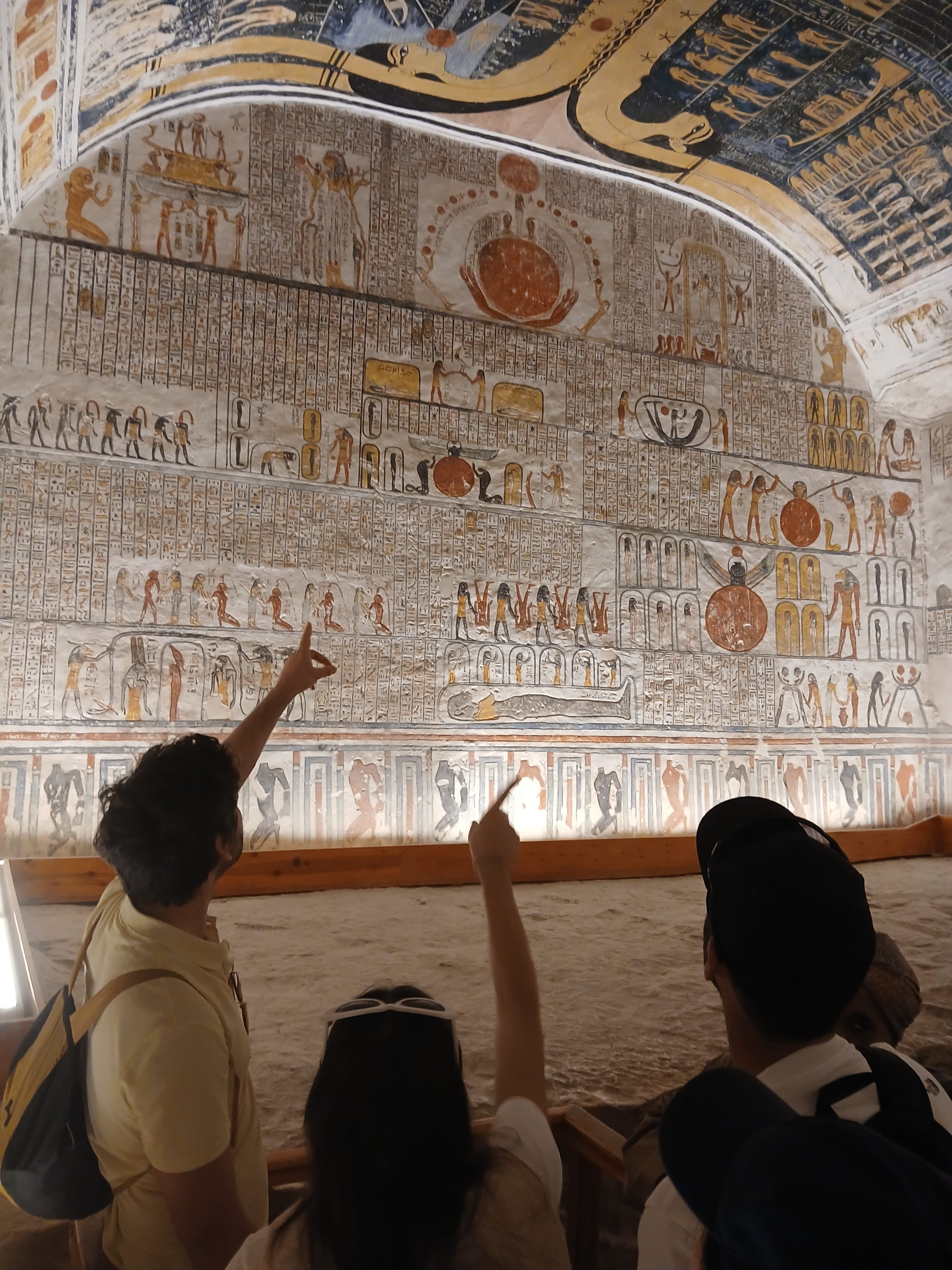 Visitors exploring the colorful reliefs at Rameses II tomb  