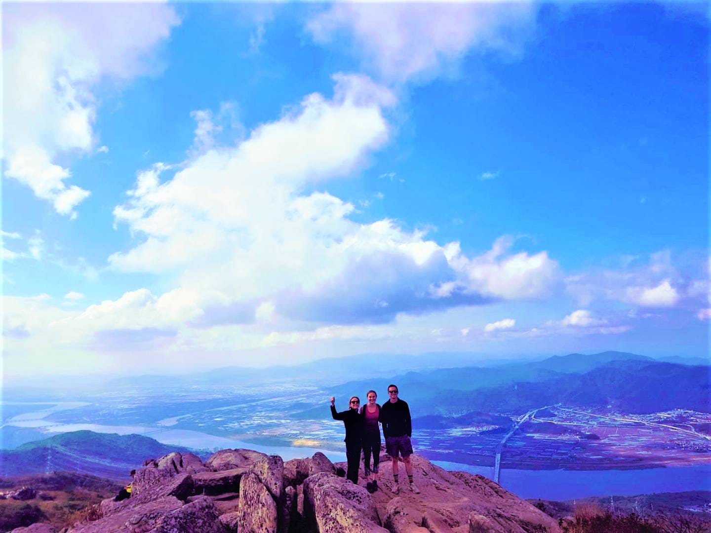 The summit marker stone at Godangbong Peak under a clear blue sky.