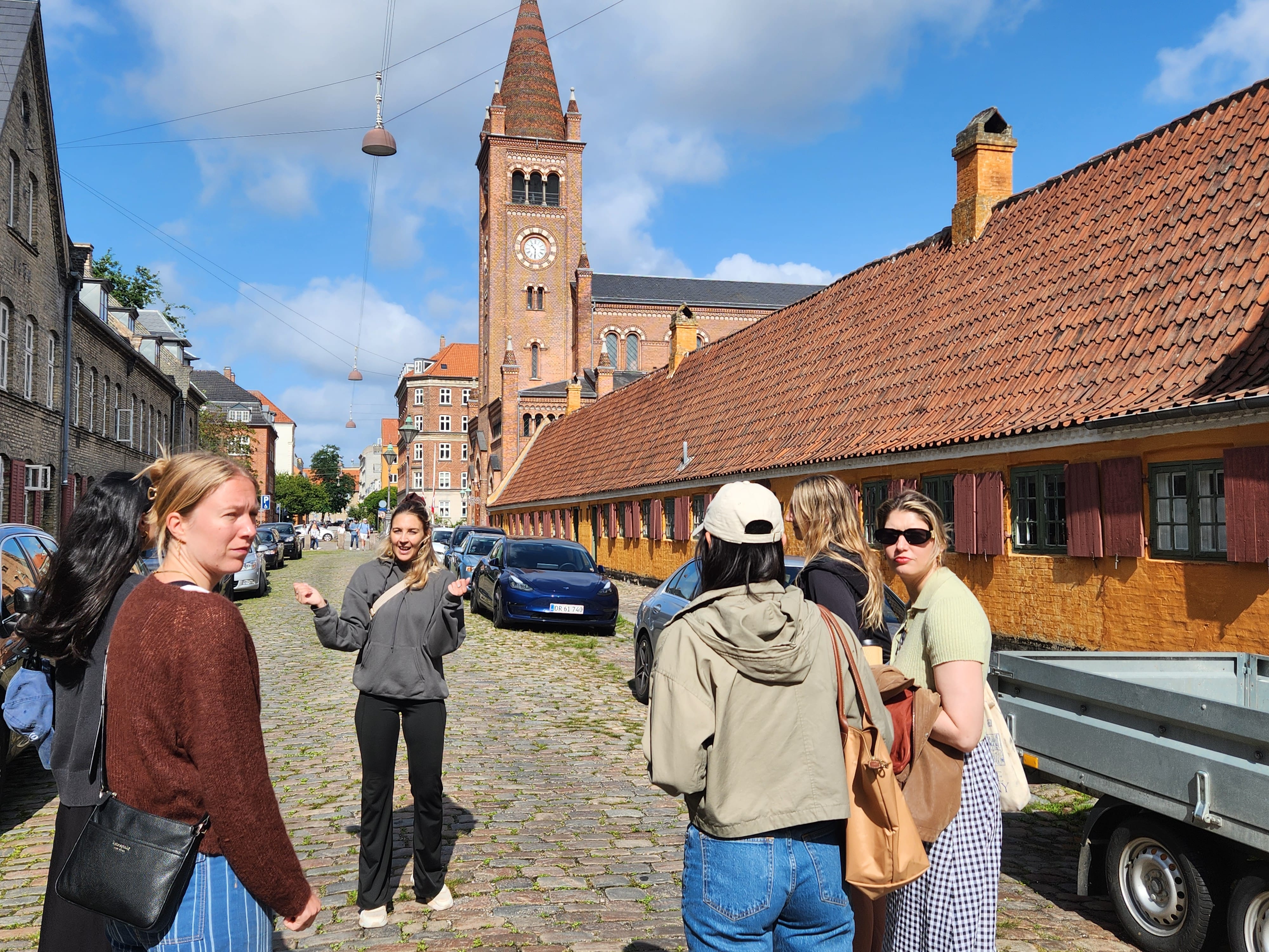 A small walking tour group in front of the Nyboder houses