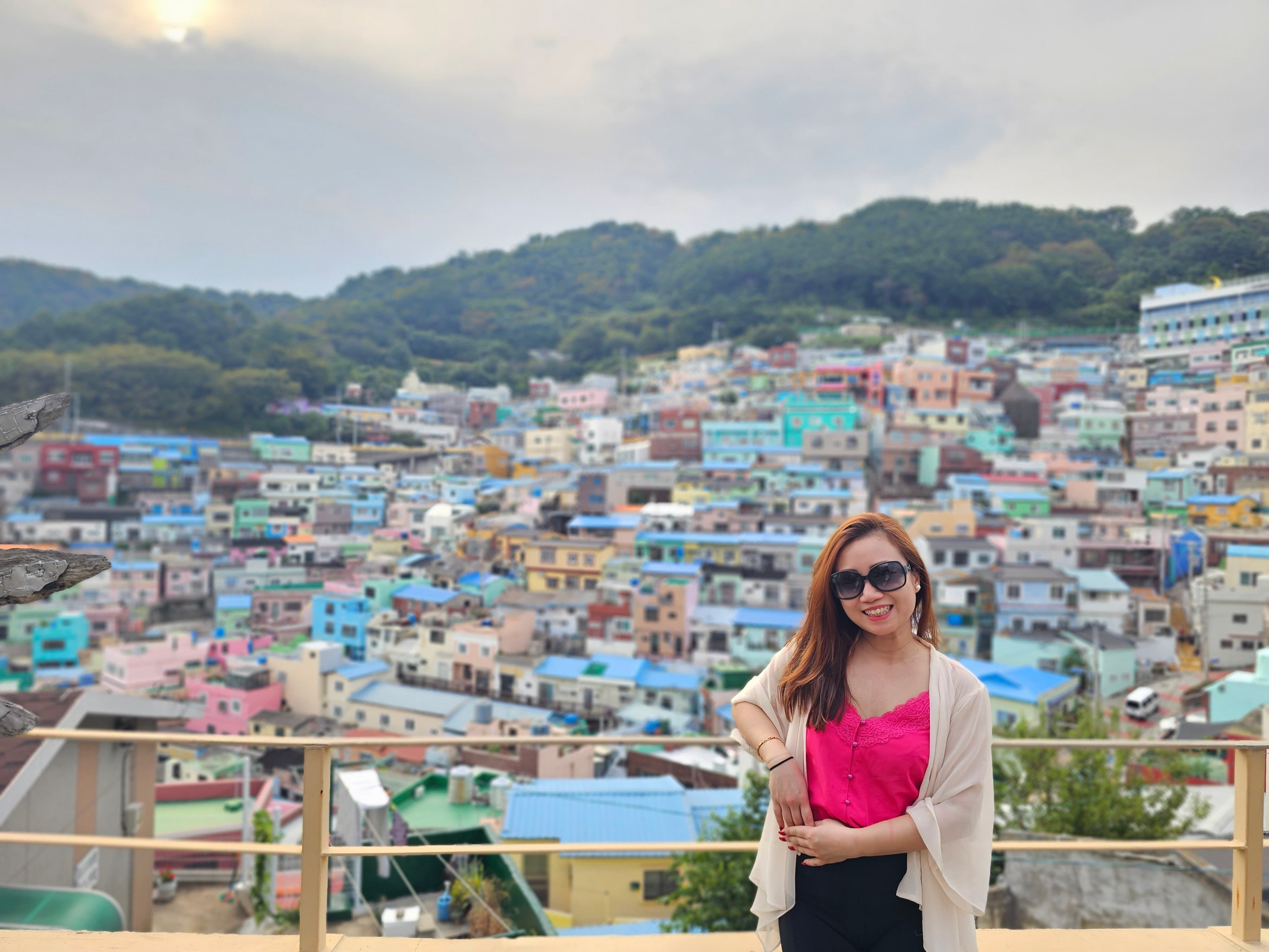 Visitors walking along the pastel-colored streets of Gamcheon Culture Village.