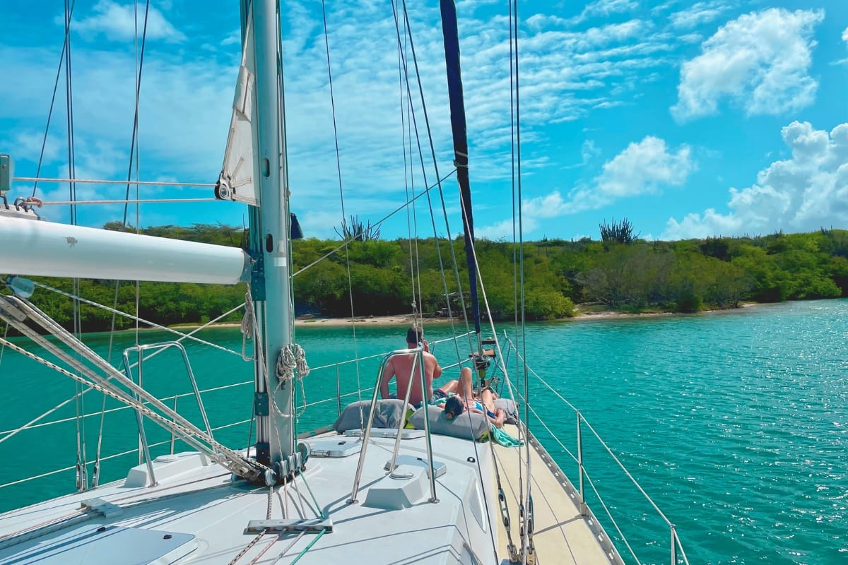 Happy couple relaxing on deck on sailing yacht with Maxie Sailing Curacao