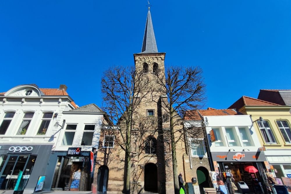View of the shopping street Ginnekestraat with church and shops along the route of the Breda escape game City Detective.