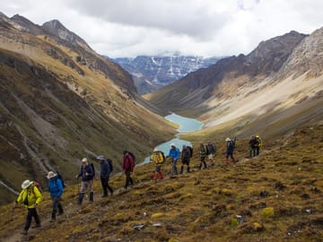 Group of trekkers hiking past the twin lake called Tsophu during Jomolhari Loop Trek