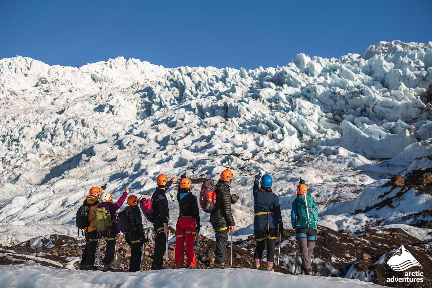 A group of hikers pointing for a photograph during Glacier hike in Iceland Skaftafell
