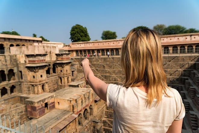 Girl-Traveler-Pointing-To-Famous Stepwell Chand Baori