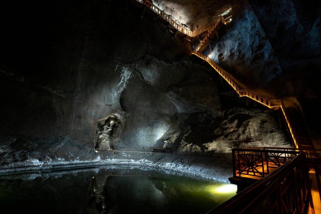 Underground salt lake with illuminated wooden walkways inside Wieliczka Salt Mine near Krakow