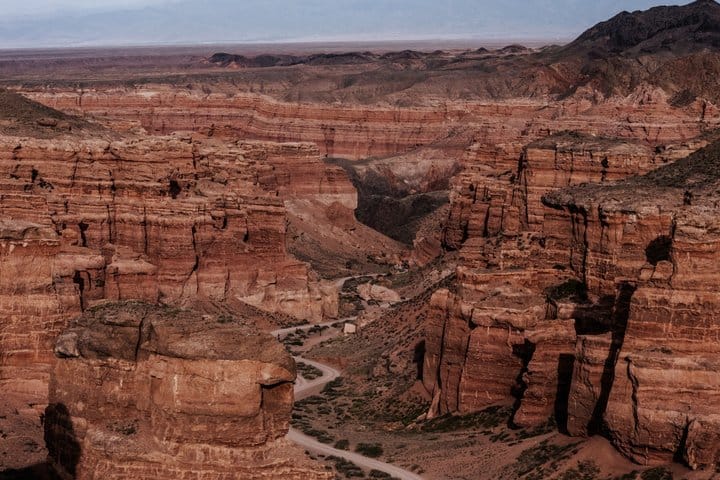Traveler path through narrow canyon surrounded by massive rock formations