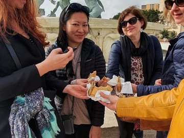 Eating Imqaret at the Triton Fountain.