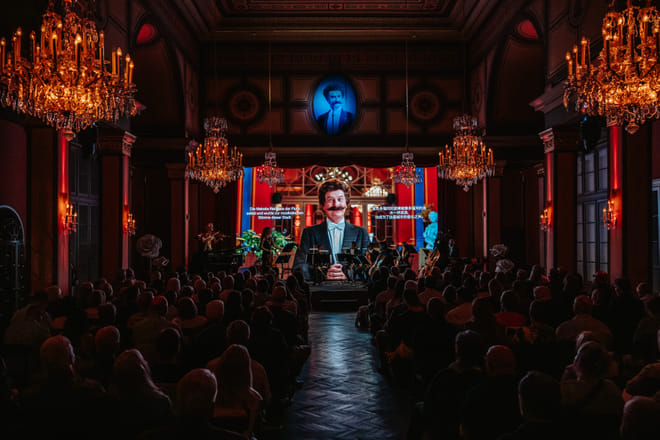 Performer on stage during live classical concert Vienna with orchestra and multimedia show