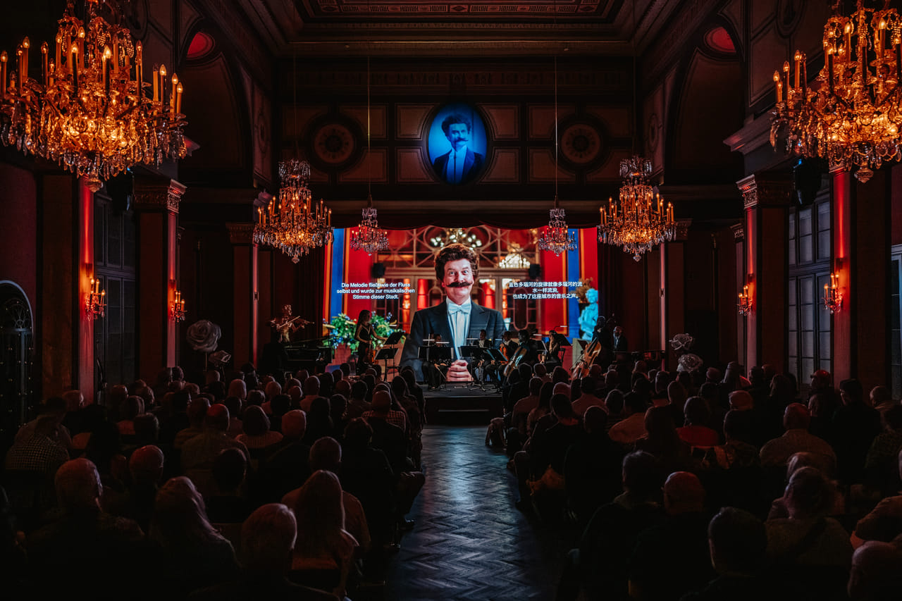 Performer on stage during live classical concert Vienna with orchestra and multimedia show