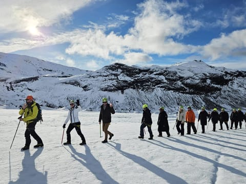 People walking in a single file line on the glacier.