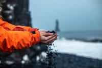 Feeling the black basalt sand on your own skin at Reynisfjara beach South Coast Iceland