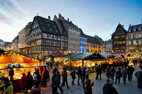 Um mercado de Natal de Estrasburgo ao entardecer, entre as casas enxaimel.