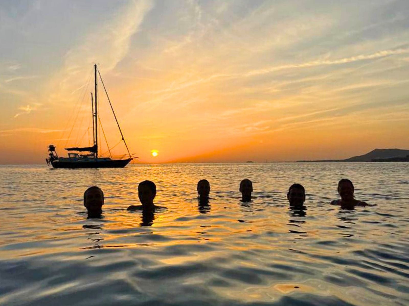 Imagen de un grupo de clientes tomando el último baño antes de la puesta de sol en la costa sur de Lanzarote.
