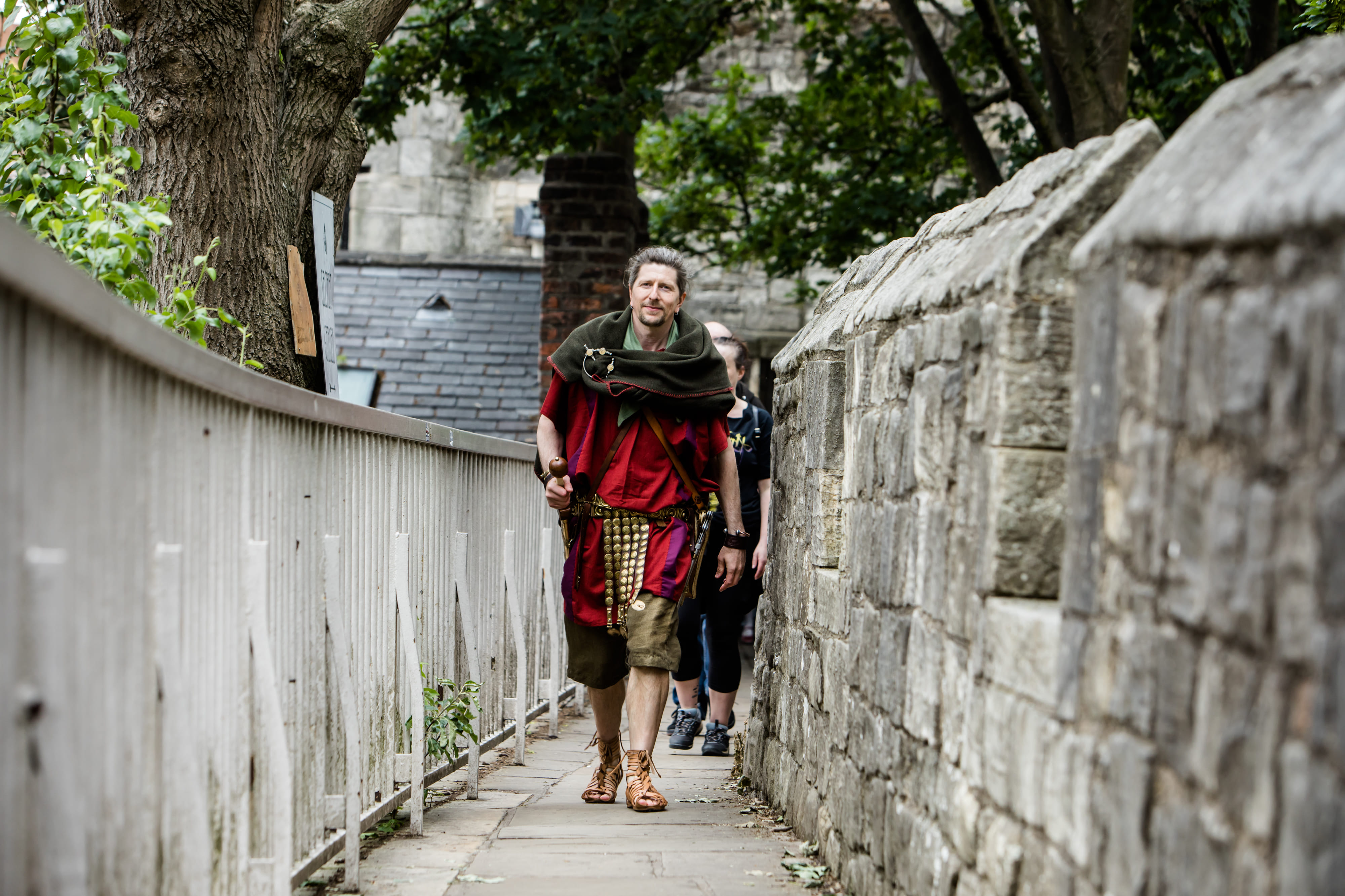 A Roman legionary walks along York city walls--medieval walls built directly on top of the Roman original.