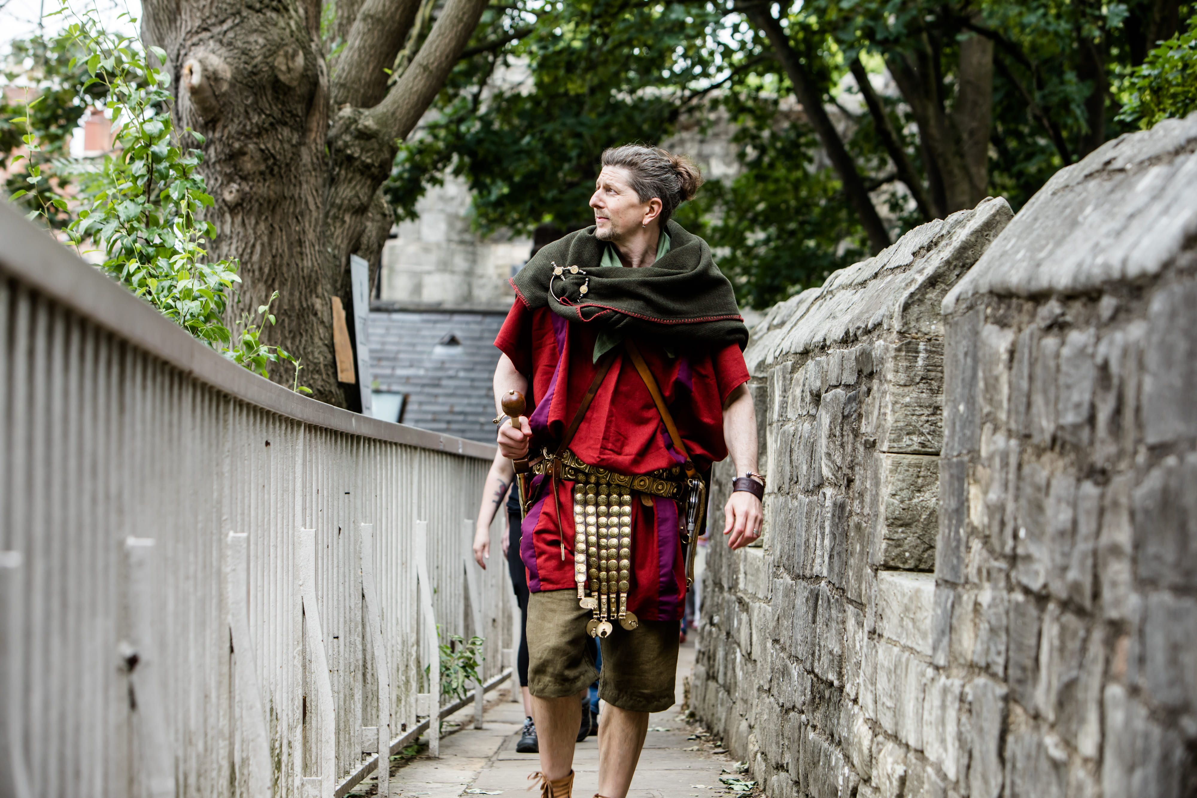 A Roman legionary walks along York city walls--medieval walls built directly on top of the Roman original.