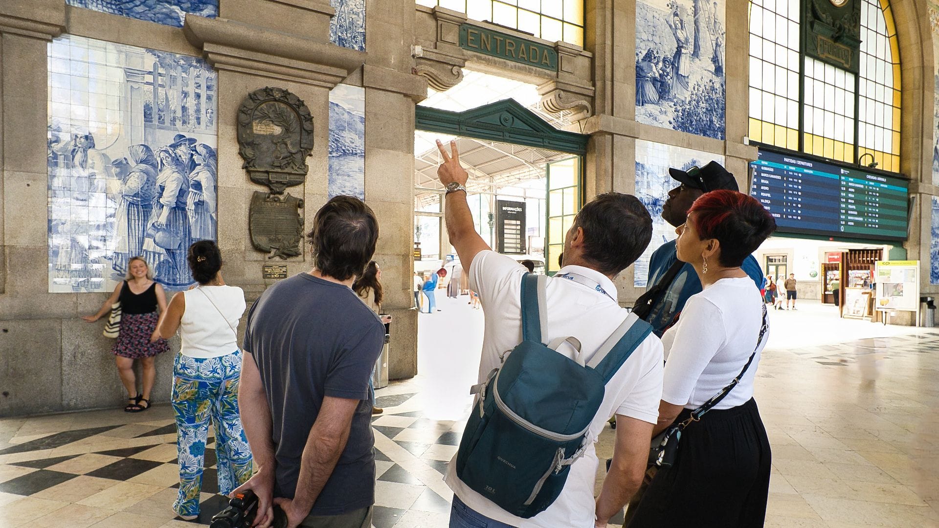 Local guide from Cooltour Oporto explains the tile murals at São Bento Station during a cultural food tour in Porto