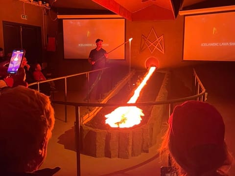 Visitors watching molten lava flow inside the Lava Show in Reykjavík, one of Iceland’s most unique volcanic experiences.