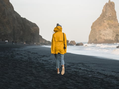A traveller walking down Reynisfjara, the black beach in Iceland