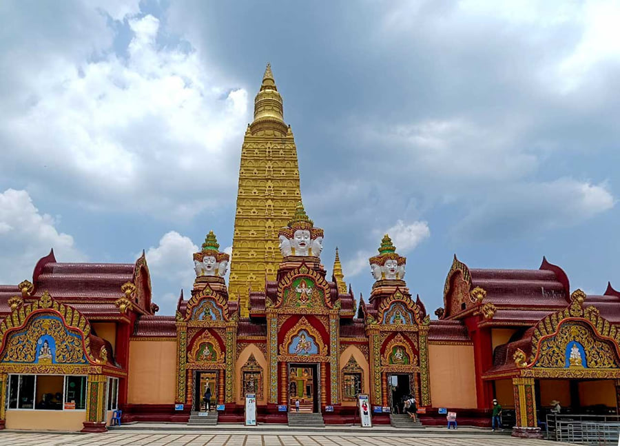 The golden chedi of Wat Bang Thong above red and gold temple halls