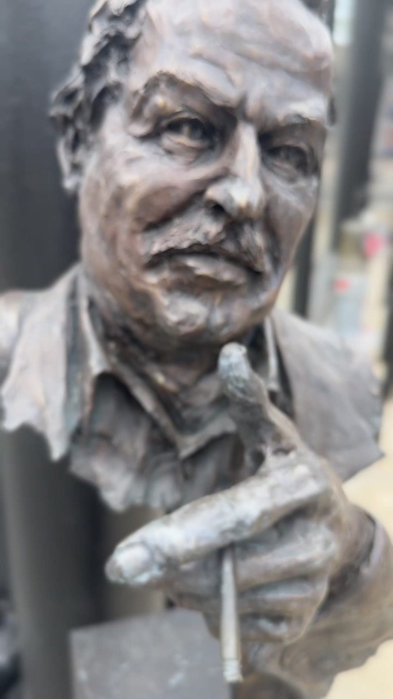 Bronze bust of playwright Tennessee Williams with a cigarette, expressive facial detail