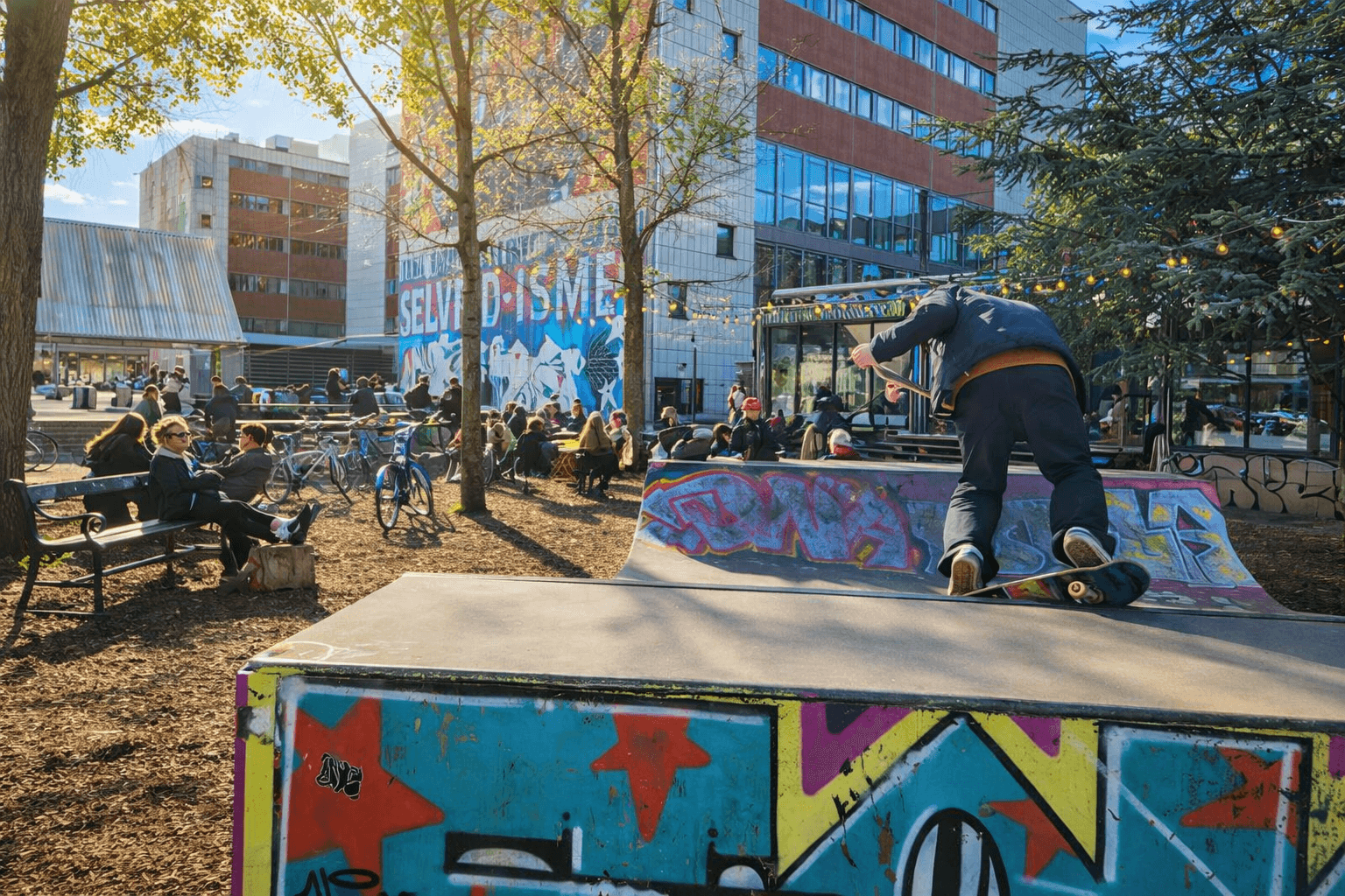 Person skateboarding at Superkilen in Nørrebro, Copenhagen, surrounded by colorful urban art and cyclists.