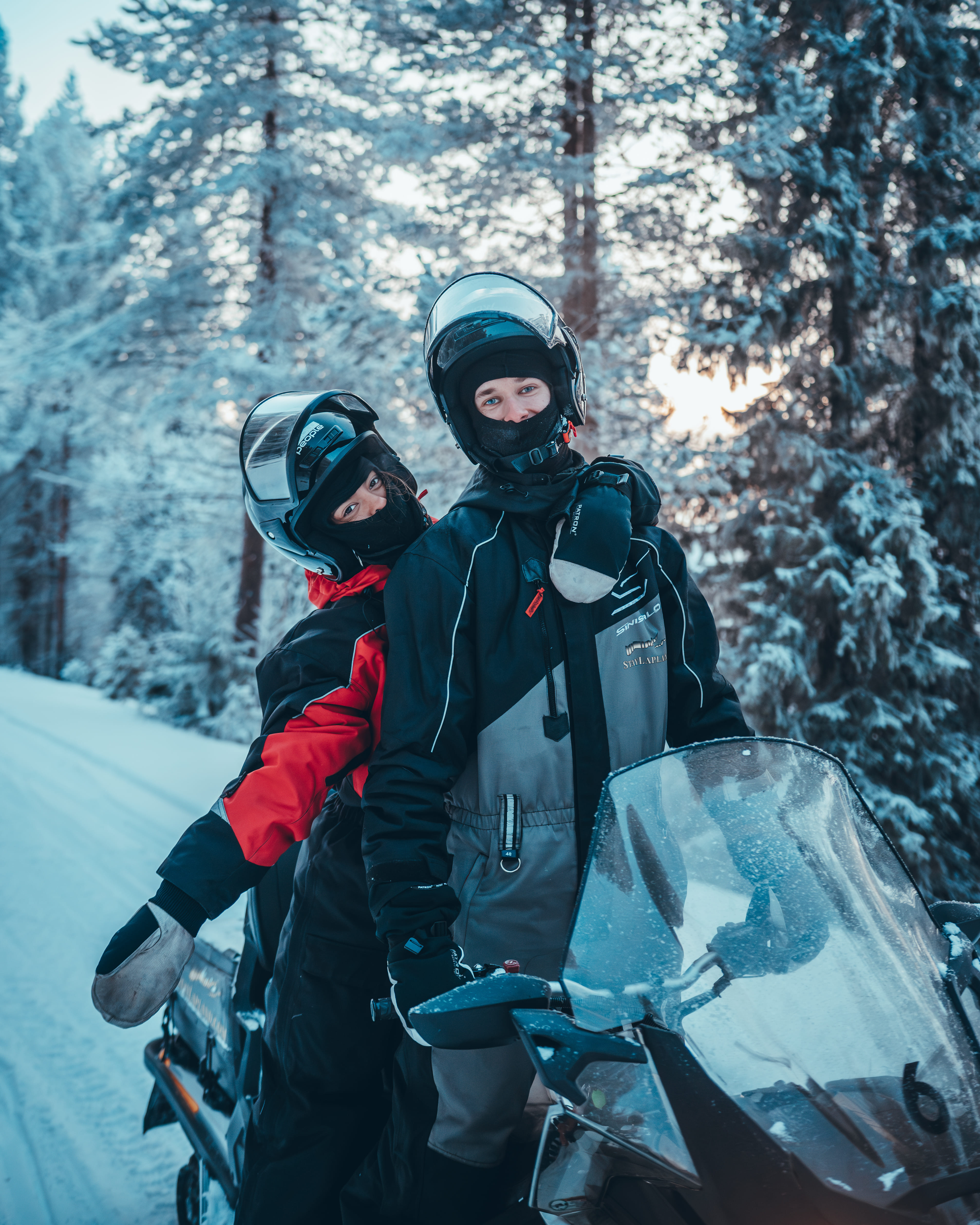 A guest driving a snowmobile through a scenic snowy forest on StayLapland's Kuoksa Husky & Snowmobile Adventure in Rovaniemi.