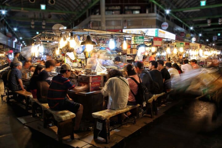 Experience authentic Korean street food at Gwangjang Market —A vendor at Gwangjang Market selling traditional Korean street food such as pancakes and seafood.