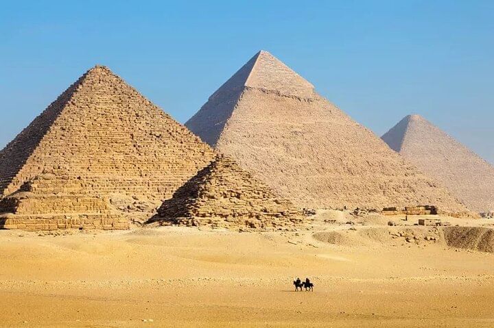 Tourists admiring the Pyramids of Giza, guided by an expert from Emo Tours Sweden.