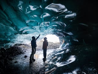 People exploring ice cave during glacier hike and ice cave tour Iceland