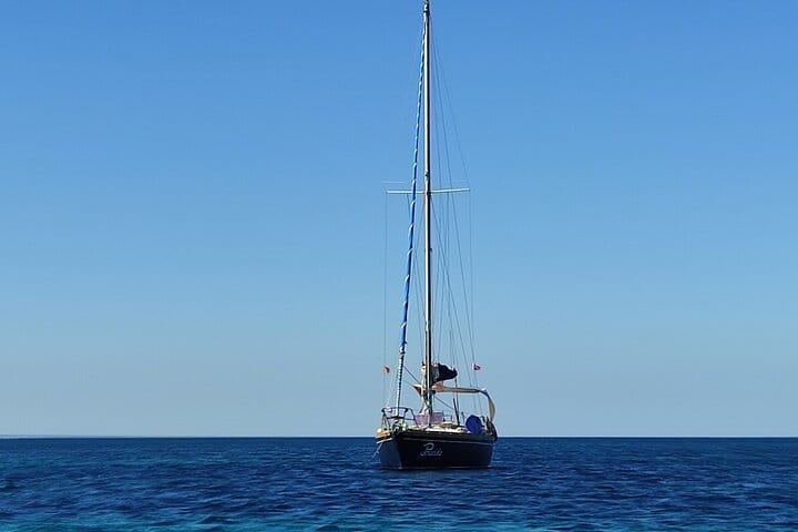 Sailing boat under clear blue sky near Ortigia, Sicily
