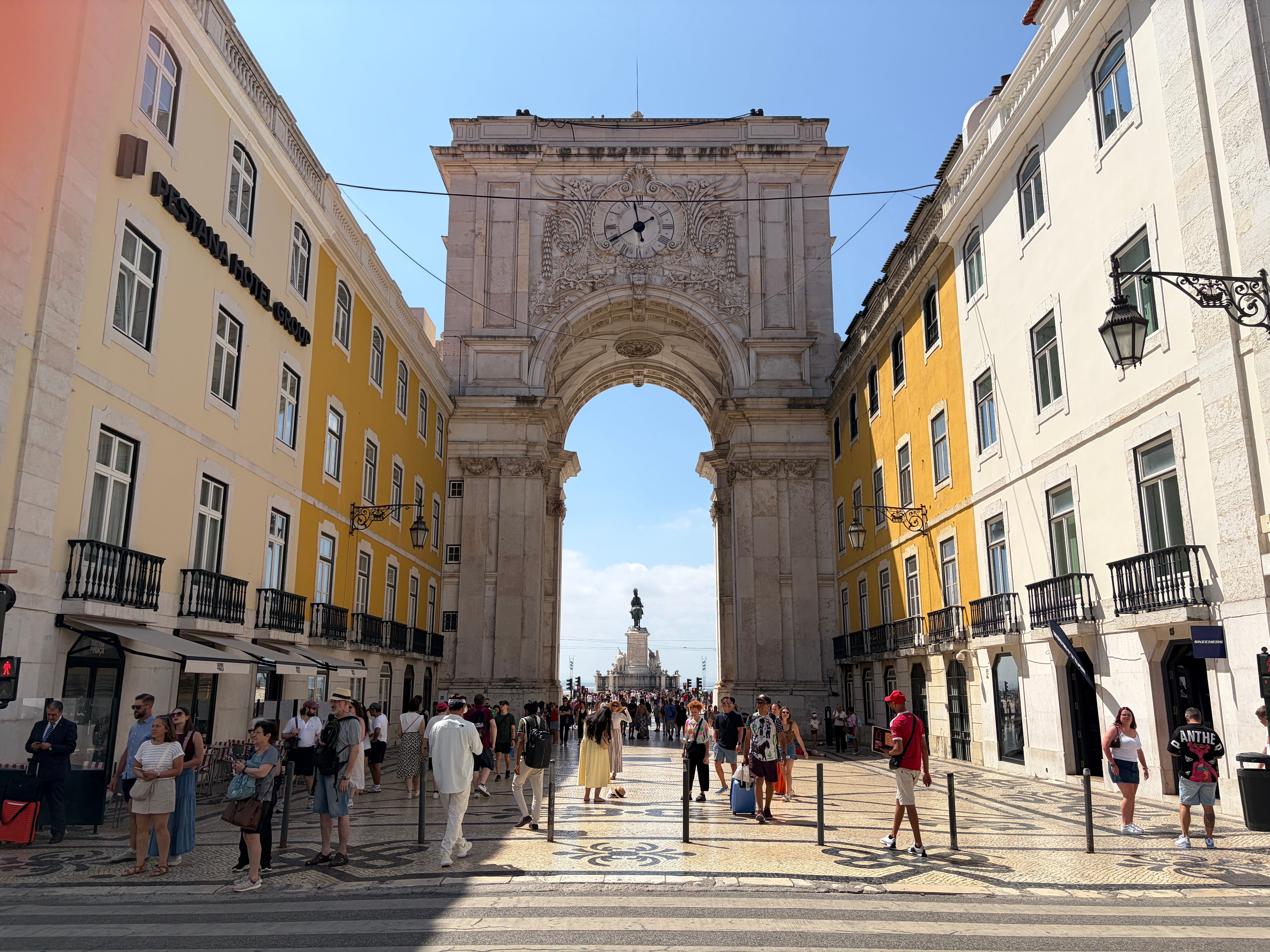 Tourists exploring the authentic cobblestone streets and colorful houses of Alfama, Lisbon's oldest district