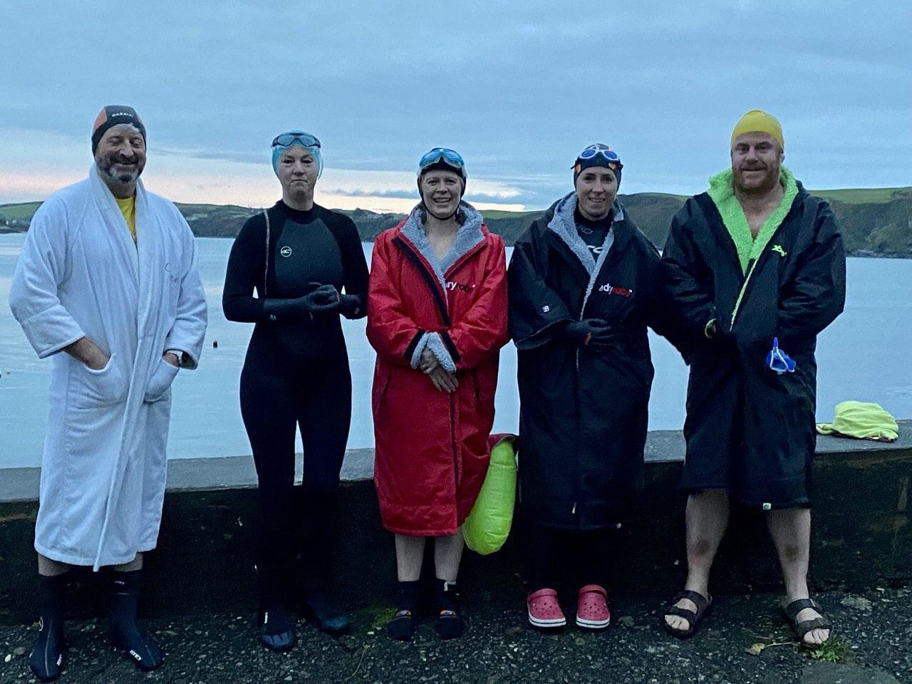 open-water swimmers dressed in winter swimming gear and robes
