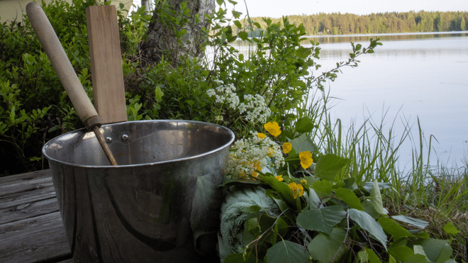A swimmer in the clear waters of the lake after experiencing a traditional Finnish sauna in Rovaniemi, StayLapland.