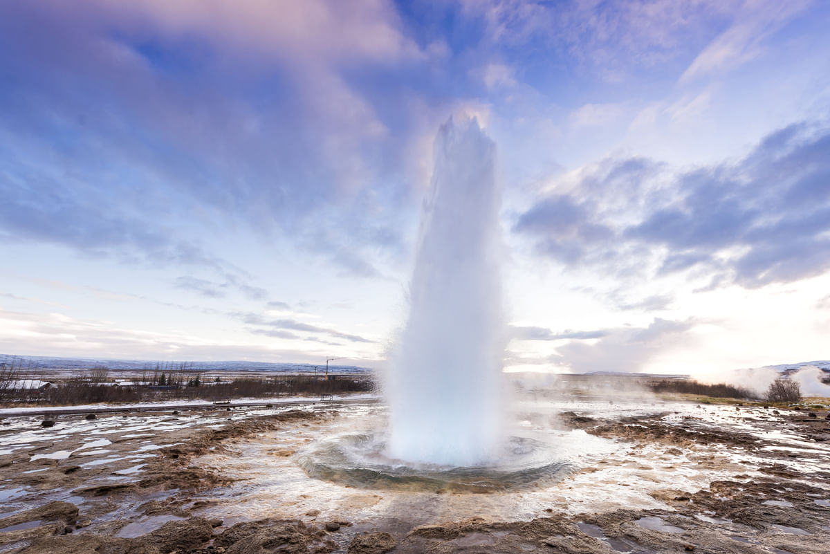 Strokkur winter with blue sky sunrise
