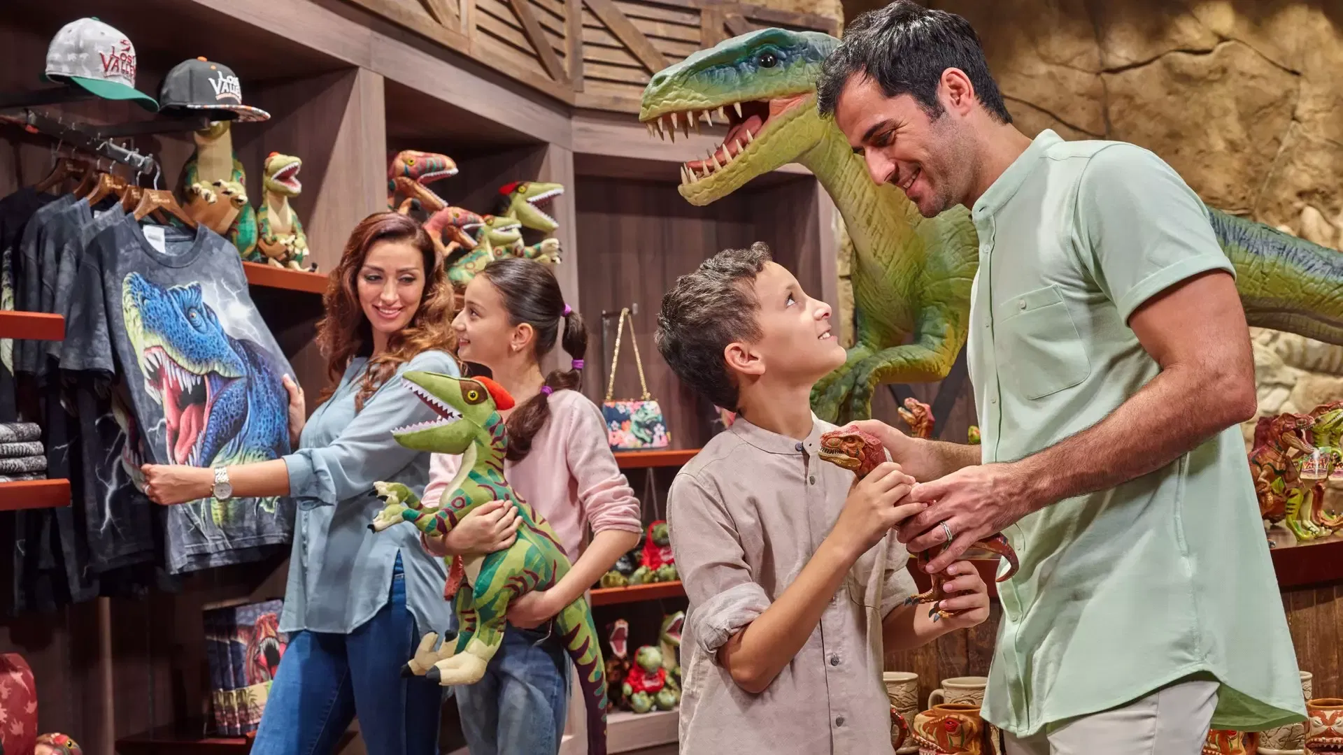 A family looks at dinosaur-themed merchandise and toys in a store at IMG Worlds of Adventure Theme Park.