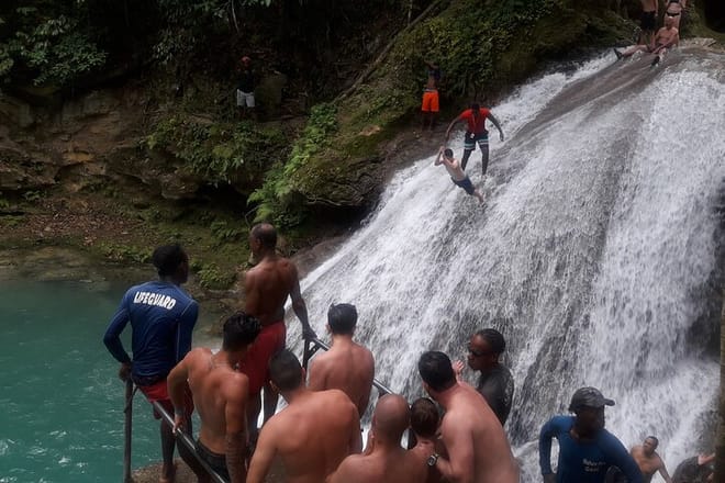 Man, about to jump off the falls, while others line up to take jumps
