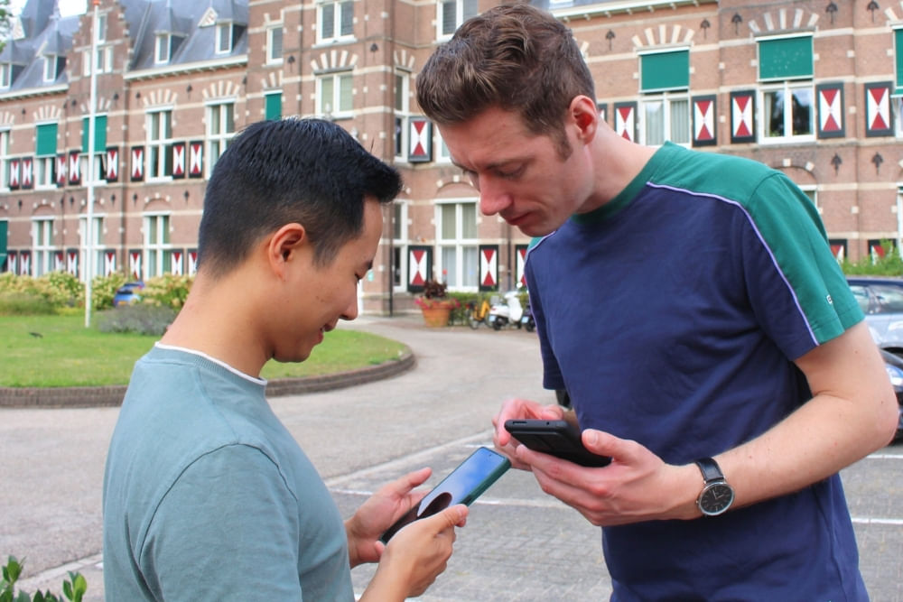 Players solving puzzles during the outdoor detective tour in Arnhem at Jansplein.