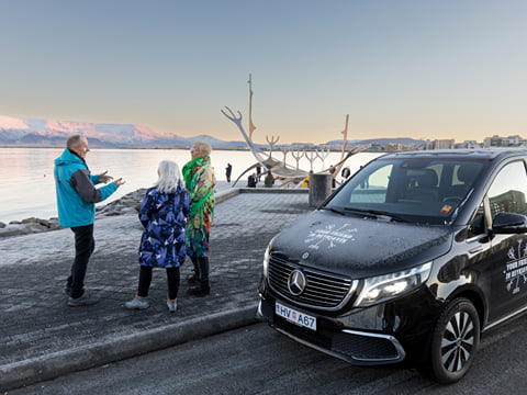 A group of travellers next to a tour vehicle from Your Friend in Reykjavik