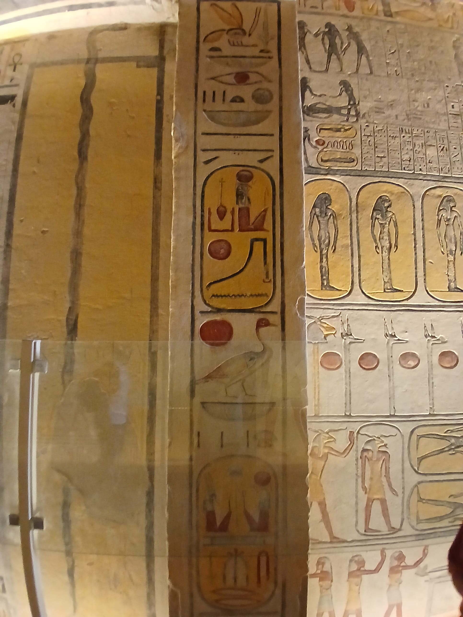 Detailed Ancient Egyptian carved wall reliefs showing deities and hieroglyphics in yellow and brown tones
