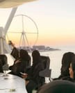 A family dining in the air at Flying Cup Dubai with smiles on their faces.